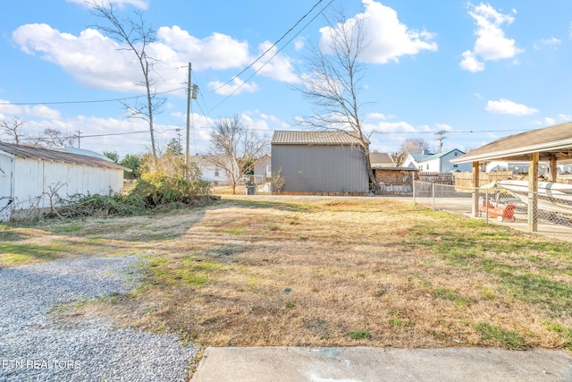 view of yard featuring a storage unit, fence, and an outbuilding