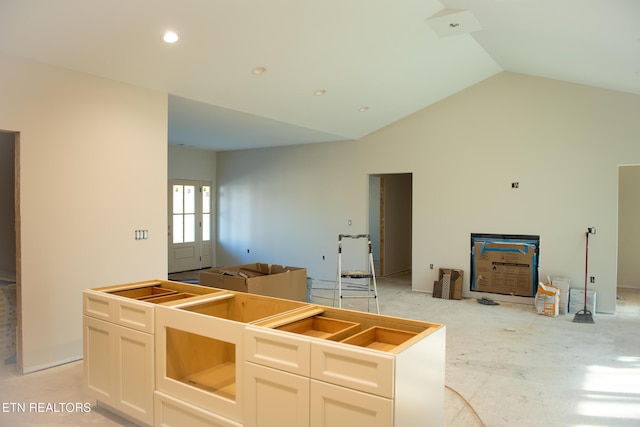 kitchen featuring white cabinetry, high vaulted ceiling, and a center island