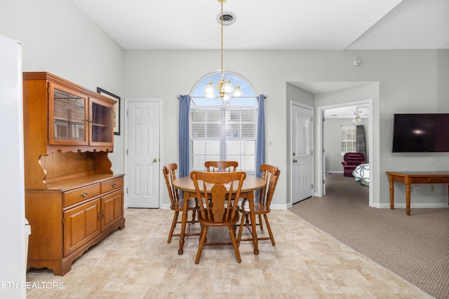 dining room with an inviting chandelier and light colored carpet