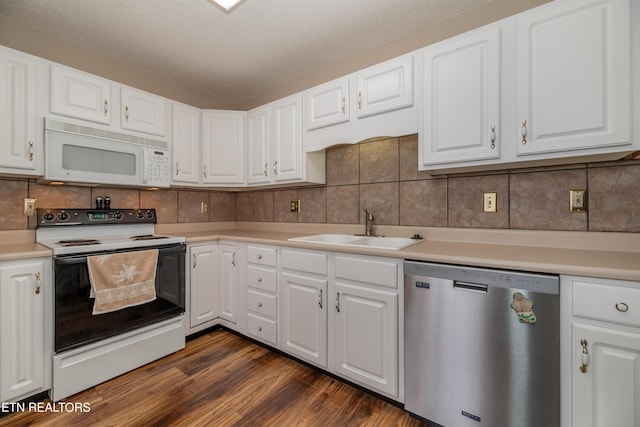 kitchen featuring white appliances, sink, dark wood-type flooring, white cabinets, and tasteful backsplash