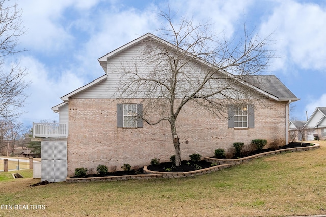 view of property exterior with a yard and a balcony