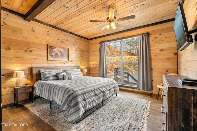 bedroom featuring wooden ceiling, wooden walls, and wood finished floors