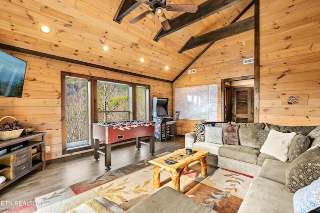 living room with lofted ceiling with beams, plenty of natural light, wooden walls, and wood ceiling