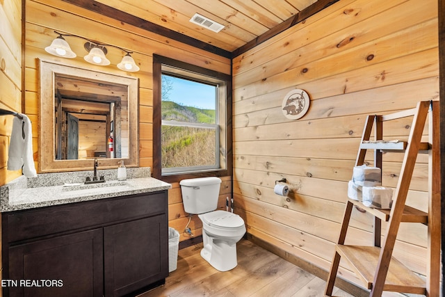 half bath featuring wood ceiling, wood walls, wood finished floors, and visible vents