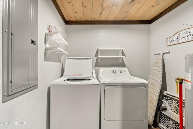 clothes washing area with laundry area, a textured wall, wood ceiling, washing machine and clothes dryer, and crown molding