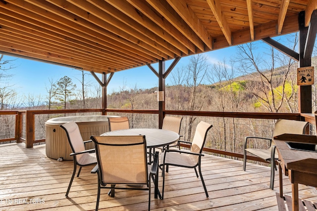 deck featuring outdoor dining space and a hot tub