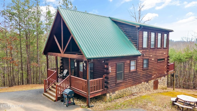 view of front of home featuring metal roof and log siding