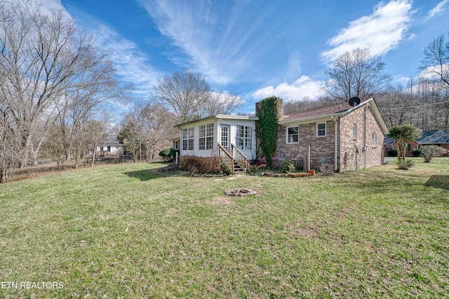 view of front of home with a front yard and a sunroom