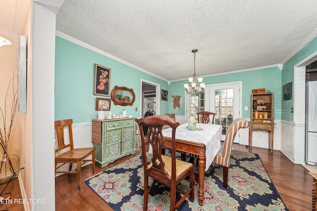 dining room with ornamental molding, a chandelier, and dark hardwood / wood-style flooring