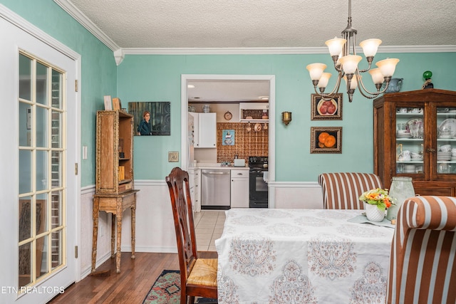 dining area featuring a textured ceiling, crown molding, and wood-type flooring