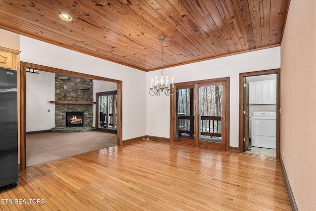 unfurnished dining area with light wood finished floors, washer / clothes dryer, wood ceiling, and crown molding