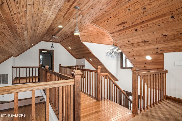 interior space featuring vaulted ceiling, hardwood / wood-style floors, wooden ceiling, and a notable chandelier