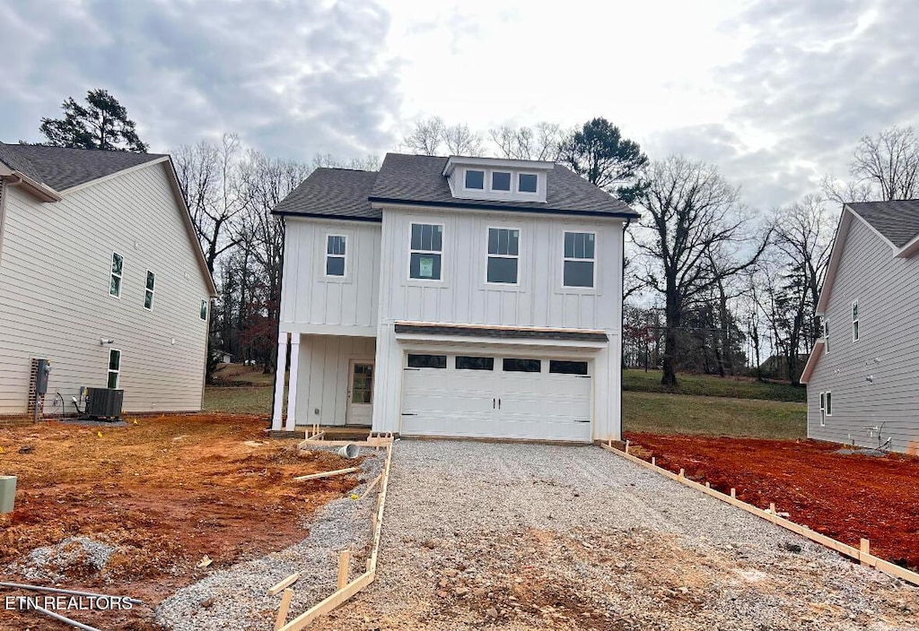 view of front of house with a garage and central air condition unit