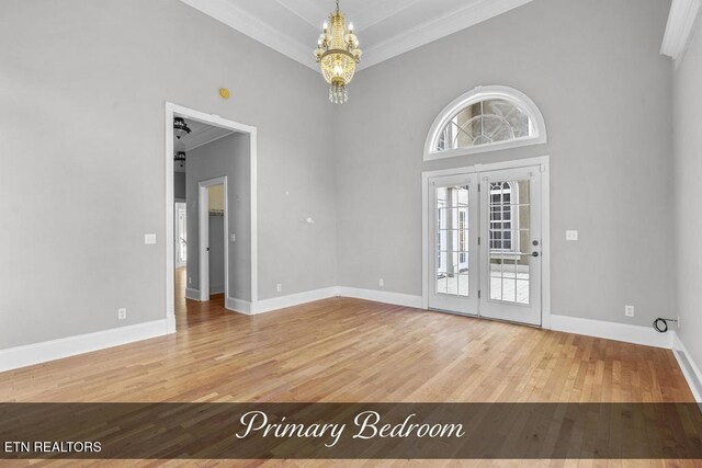 foyer entrance with baseboards, wood finished floors, and french doors