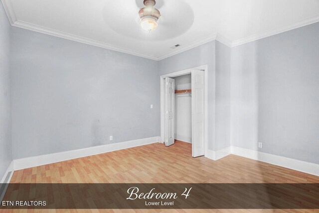 unfurnished bedroom featuring baseboards, wood finished floors, and crown molding