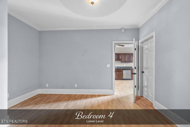 empty room featuring ornamental molding, light wood finished floors, and baseboards