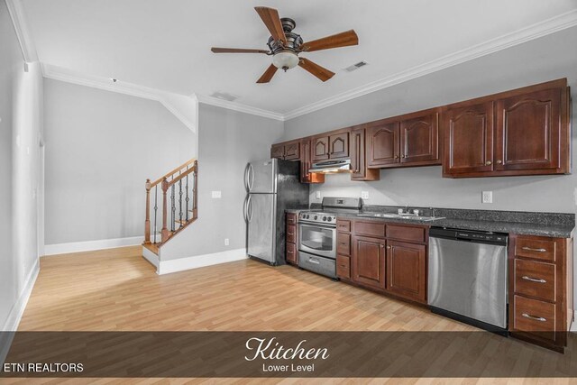 kitchen featuring visible vents, dark countertops, appliances with stainless steel finishes, crown molding, and under cabinet range hood