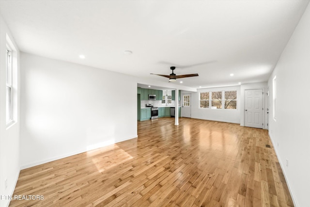 unfurnished living room featuring ceiling fan, recessed lighting, baseboards, and light wood-style floors