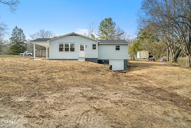 rear view of house featuring an attached garage, a carport, and entry steps