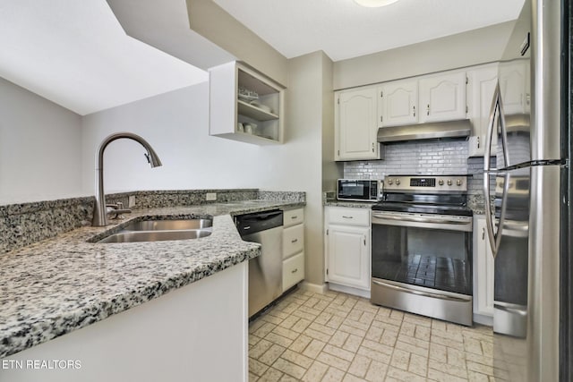 kitchen featuring appliances with stainless steel finishes, light stone countertops, under cabinet range hood, white cabinetry, and a sink