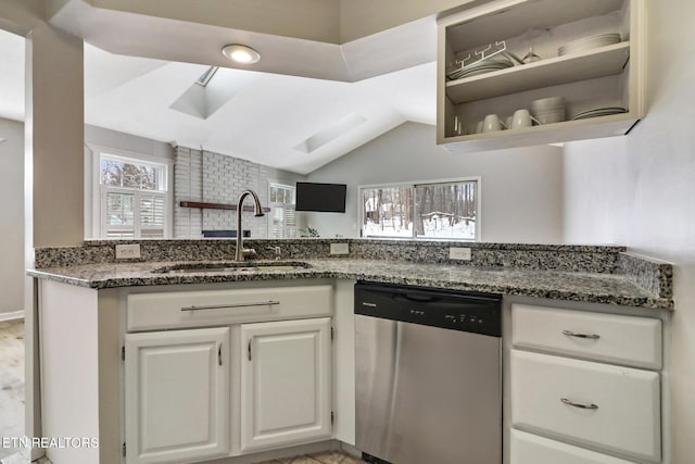 kitchen featuring a sink, white cabinets, dishwasher, open shelves, and dark stone countertops