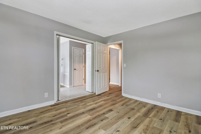 unfurnished bedroom with light wood-style floors, visible vents, and baseboards