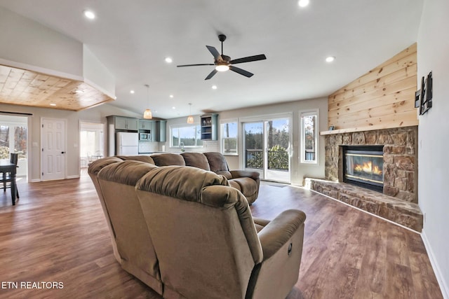 living area featuring lofted ceiling, a healthy amount of sunlight, and wood finished floors