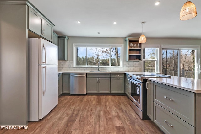 kitchen with a sink, dark wood-type flooring, appliances with stainless steel finishes, and gray cabinets