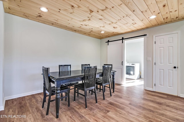 dining room featuring wood ceiling, washer / clothes dryer, a barn door, and wood finished floors