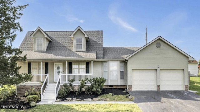 new england style home with covered porch and a garage