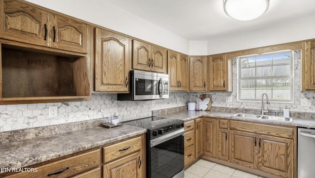 kitchen with appliances with stainless steel finishes, sink, backsplash, and light tile patterned floors