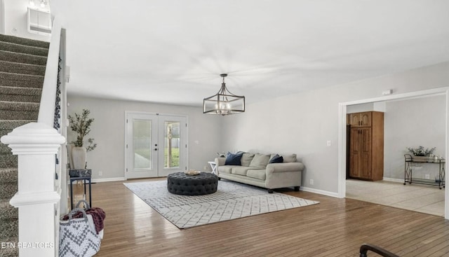 living room featuring hardwood / wood-style flooring, a chandelier, and french doors