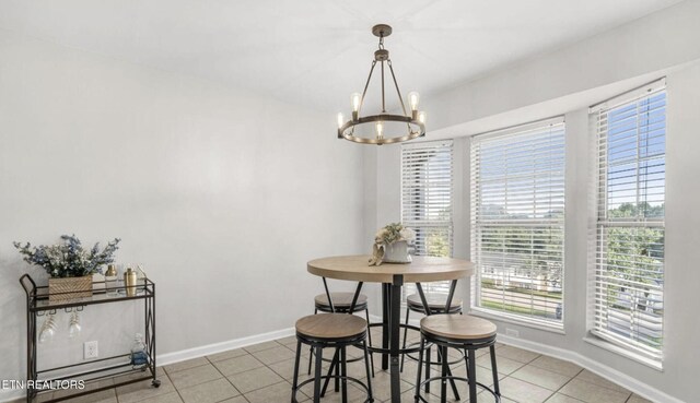 tiled dining space with a notable chandelier