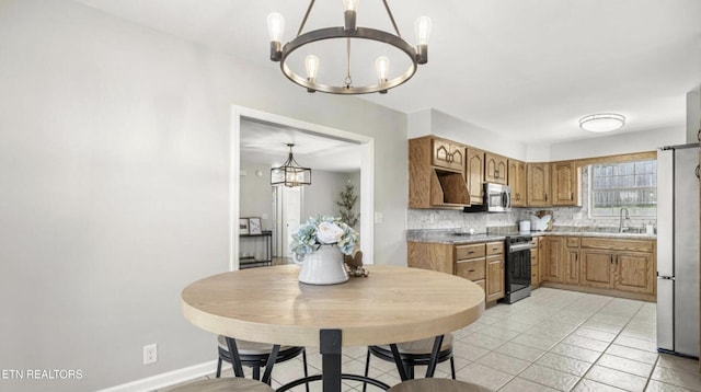 kitchen featuring appliances with stainless steel finishes, a notable chandelier, and decorative light fixtures