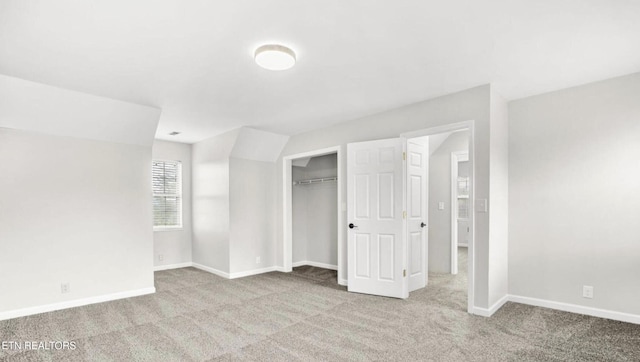 unfurnished bedroom featuring light carpet and a closet