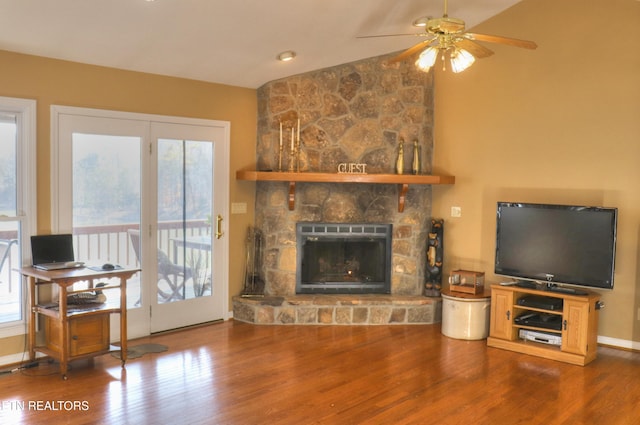 living area with lofted ceiling, a fireplace, plenty of natural light, and wood finished floors