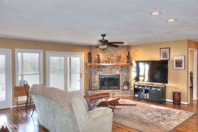 living area featuring baseboards, ceiling fan, wood finished floors, a fireplace, and recessed lighting