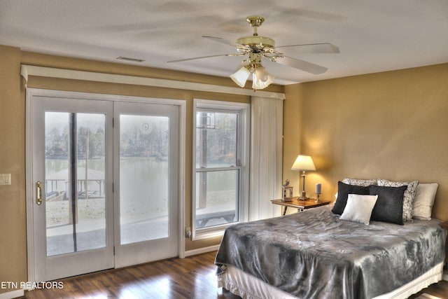 bedroom featuring a ceiling fan, access to outside, visible vents, and wood finished floors