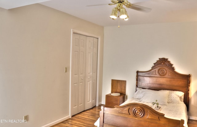 bedroom with a closet, wood finished floors, a ceiling fan, and baseboards