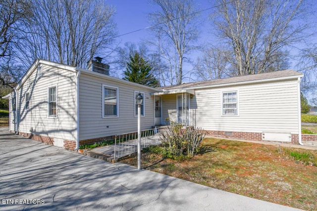 view of front of home featuring crawl space and a chimney