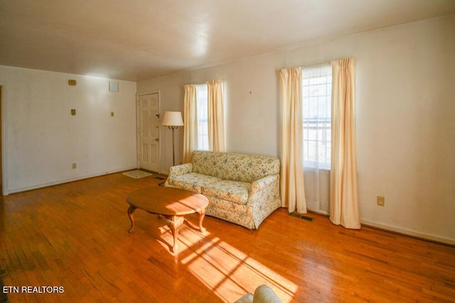 unfurnished living room featuring visible vents, baseboards, and hardwood / wood-style flooring