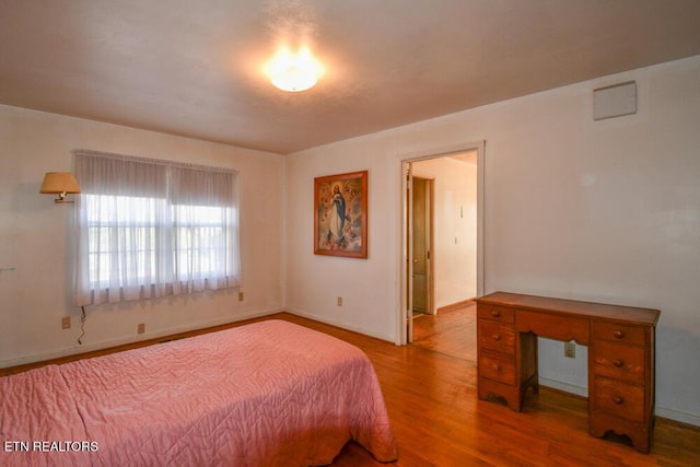 bedroom with baseboards and wood finished floors