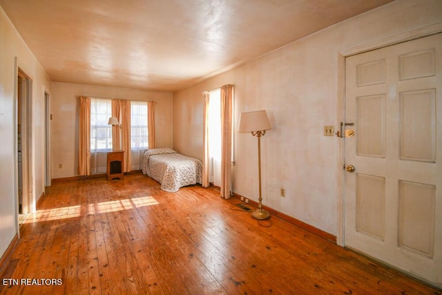 unfurnished bedroom featuring light wood-type flooring and baseboards