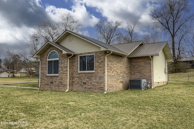 view of side of property with central AC, crawl space, a yard, and brick siding