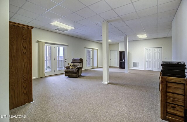 basement featuring carpet floors, visible vents, and a drop ceiling