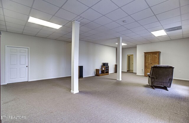 finished basement with carpet floors, baseboards, and a drop ceiling