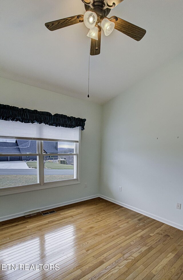 unfurnished room featuring light wood-type flooring, visible vents, ceiling fan, and baseboards