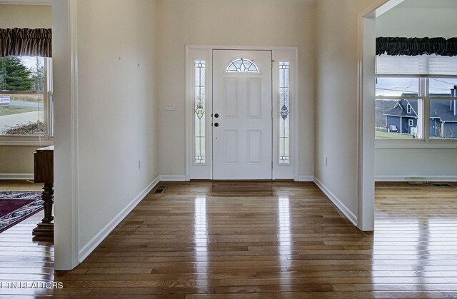 foyer entrance with dark wood-style floors and baseboards