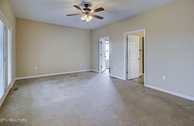 spare room featuring ceiling fan, carpet floors, visible vents, and baseboards