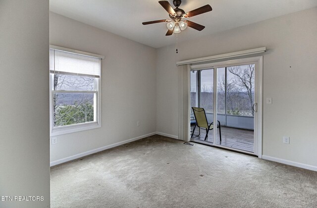 spare room featuring carpet floors, visible vents, ceiling fan, and baseboards